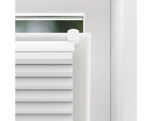 Detailansicht eines weißen Plissees am Fenster