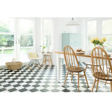 Pièce lumineuse avec sol à damier, table à manger et chaises.