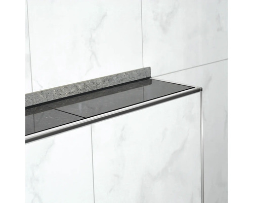 Gros plan d''une salle de bains avec un plan de travail noir et une crédence grise sur des carreaux de marbre blanc