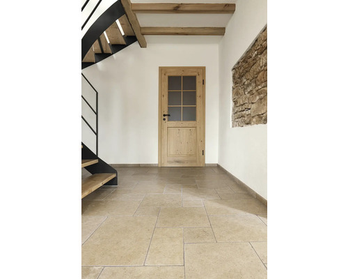 Innenraum mit Holztreppe, Holzbalken, Holztür und Steinfliesenboden