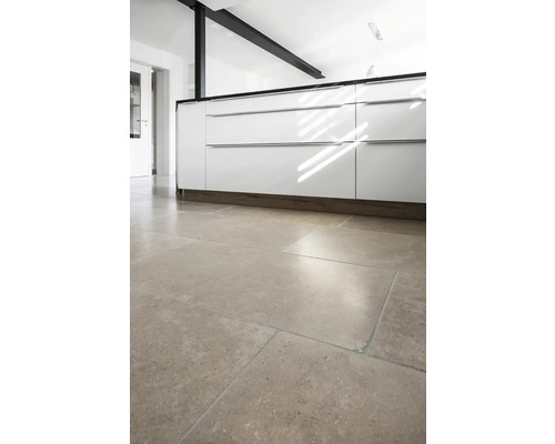 Küchenszene mit weißen Schränken und Bodenfliesen.