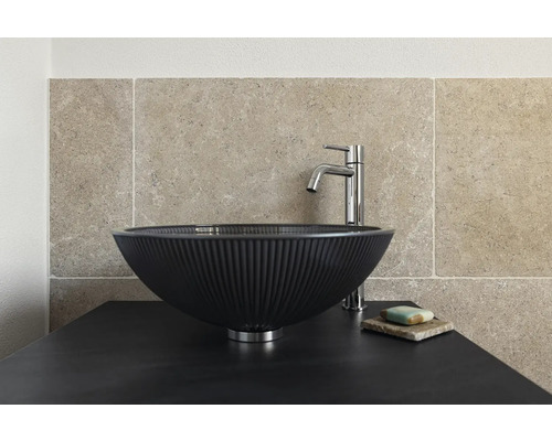 Auf einer Waschtischplatte steht ein Aufsatzwaschbecken mit Armatur und Seife.