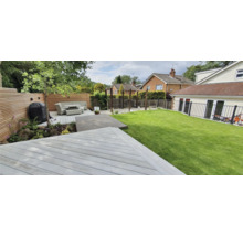 Garten mit Terrasse, Rasenfläche und Sitzbereich mit Grill.