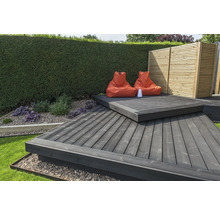 Gartenszene mit Holzterrasse, Sitzsäcken und Gartenzaun