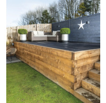 Gestalteter Gartenbereich mit Holzterrasse, Gartenmöbeln und dekorativer Bepflanzung