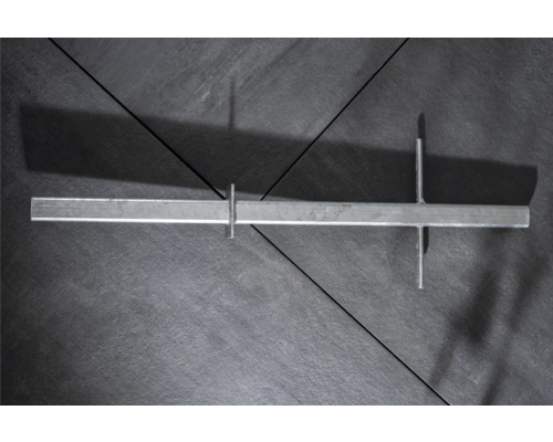 Verzinkte Metallschiene mit Befestigungselementen auf dunklem Untergrund