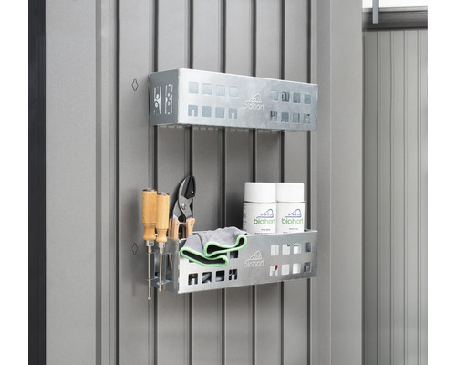 Deux étagères en métal avec outils, chiffons de nettoyage et aérosols sur un mur