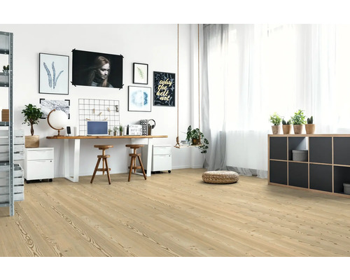 Espace de travail lumineux avec plancher en bois, bureau et objets de décoration.