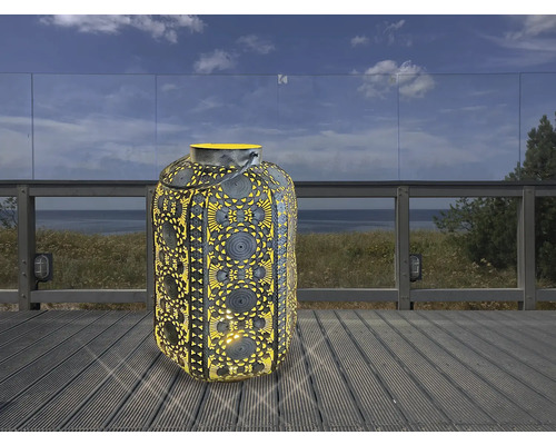 Lanterne de jardin décorative avec motif perforé sur une terrasse