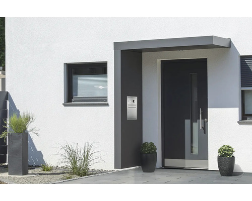 Eingangsbereich eines Hauses mit Haustür, Fenster und Pflanzenkübeln