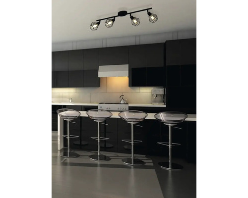 Moderne Küche mit schwarzer Küchenzeile, transparenten Barhockern und einer schwarzen Deckenleuchte mit vier Strahlern.