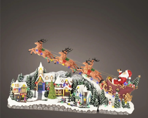 Décoration de Noël avec le Père Noël en traîneau survolant un village enneigé