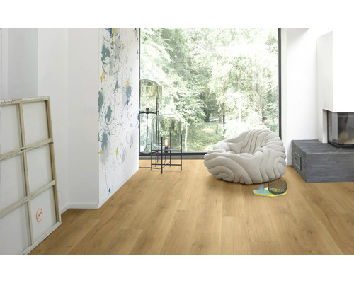 Pièce lumineuse avec sol stratifié, fauteuil et cheminée