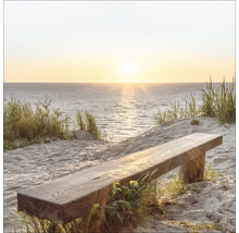 Holzbank auf Sand am Meer mit Blick auf den Sonnenuntergang