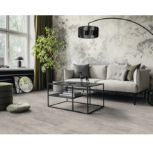 Salon lumineux avec canapé, table basse et lampadaire