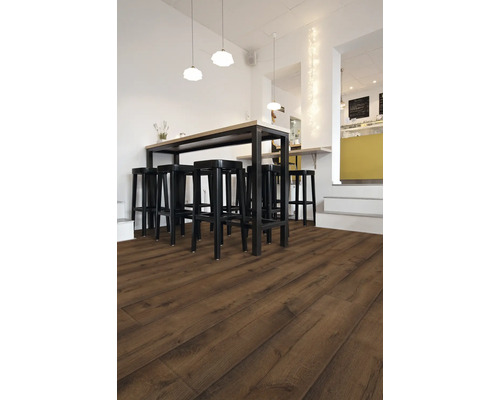Intérieur avec sol stratifié foncé, table haute et tabourets de bar noirs.