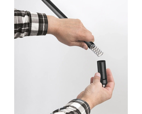 Eine Person verbindet eine Teleskopstange mit einem Sprinkler.