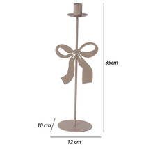 Beiger Kerzenständer aus Metall mit dekorativer Schleife, Höhe 35 Zentimeter, Breite 12 Zentimeter, Tiefe 10 Zentimeter.