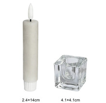 Bougie LED beige 2,4 par 14 centimètres avec bougeoir carré en verre 4,1 par 4,1 centimètres.